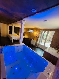 a large blue tub in a room with a bedroom at Le Cupidon & Spa in Pont-Sainte-Maxence