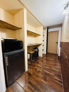 a kitchen with a black refrigerator in a room at Le Cupidon & Spa in Pont-Sainte-Maxence
