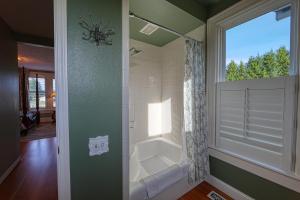 a bathroom with a shower and a window with a tub at The Allen House in Ridgefield