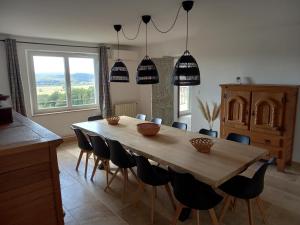 a dining room with a wooden table and chairs at La maison in Cruviers-Lascours