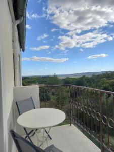 a balcony with a table and chairs and a view at La maison in Cruviers-Lascours