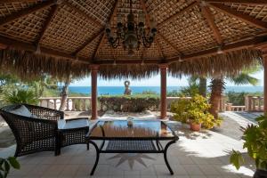 a patio with a table and chairs under a straw umbrella at La Valise Los Cabos, Member of Small Luxury Hotels in Boca de la Vinorama