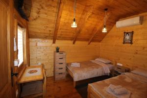 a bedroom with two beds in a log cabin at Etno Lug - Village in Bogetići