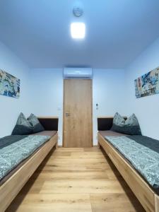 two beds in a room with a door at Resort Winklfeld 6a in Oberndorf bei Schwanenstadt