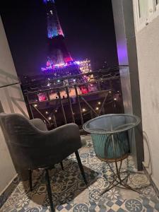 a chair and a table and a view of the eiffel tower at HNC Arcade in Dargai