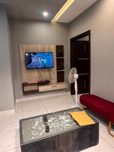 a living room with a tv and a red couch at HNC Arcade in Dargai