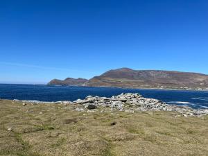 a view of the ocean with mountains in the background at High Road Cottage in Dooagh +10 photos