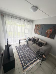 a living room with a couch and a window at Monochrome View in Nelspruit
