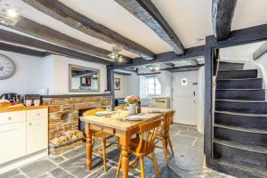 a kitchen and dining room with a wooden table and chairs at 1 Bed in Looe oc-l30002 in Looe