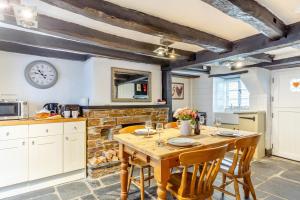 a kitchen with a wooden table and a fireplace at 1 Bed in Looe oc-l30002 in Looe +12 photos