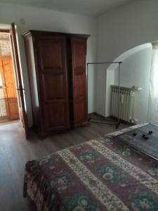 ein Schlafzimmer mit einem Bett und einer Holztür in der Unterkunft Seconda Casa in Boves
