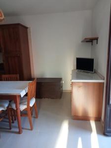 ein Zimmer mit einem Tisch und eine Küche mit einer Mikrowelle in der Unterkunft Seconda Casa in Boves