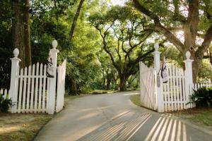 een witte poort op een weg met bomen bij The Myrtles in Saint Francisville