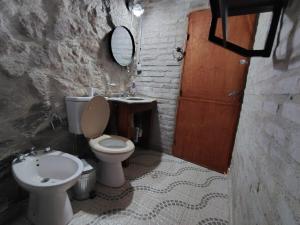 a bathroom with a toilet and a sink and a mirror at Stone Cabin, PETRA HAUS in Cuesta Blanca +34 photos
