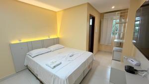 a bedroom with a large white bed and a telephone at Hotel Diamond Exclusive in Oiapoque