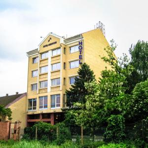 un edificio amarillo con un cartel. en Hotel Chesscom, en Budapest