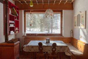 a dining room with a table and a window at Prali Ski House - 4beds - Parking - Garden in Prali