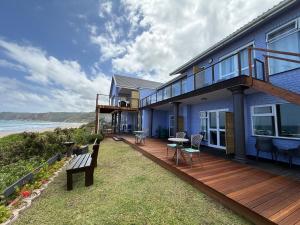 a house with a wooden deck next to the ocean at Sea Paradise in Wilderness