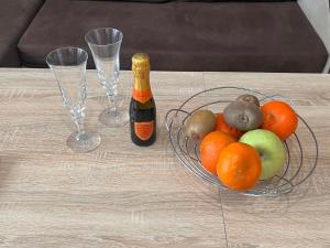 a table with a bowl of fruit and a bottle of champagne at Апартамент Аксел in Panagyurishte +5 photos