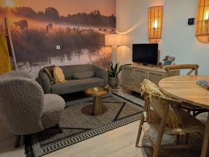 a living room with a couch and a tv at Een Nije Dei in Arum