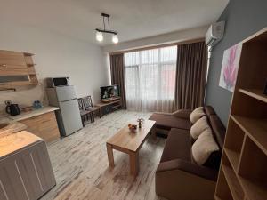 a living room with a couch and a table at Апартамент Аксел in Panagyurishte