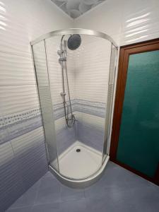 a shower with a glass enclosure in a bathroom at Апартамент Аксел in Panagyurishte