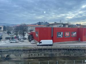 a white van parked in front of a red building at Апартамент Аксел in Panagyurishte