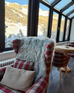 a living room with a couch and a table and windows at Grifone Dolomiti Residences in Arabba
