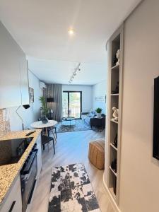 a kitchen and a living room with a table at Platform 123 - 2 On Tabak with onsite Parking in Paarl