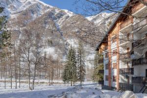 a snow covered mountain in front of a building at Prali Ski House - 4beds - Parking - Garden in Prali