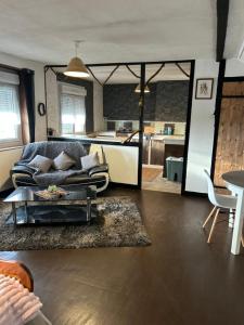 a living room with a couch and a kitchen at Chambre d'hôte Mara in Corlay +25 photos