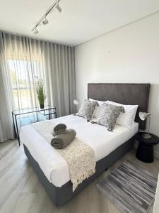 a bedroom with a large bed with towels on it at Platform 123 - 2 On Tabak with onsite Parking in Paarl