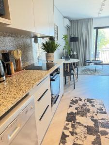 a kitchen with white cabinets and a counter top at Platform 123 - 2 On Tabak with onsite Parking in Paarl