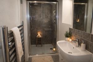 a bathroom with a shower and a sink with candles at Crayford's Guest House in Aberdeen +13 photos