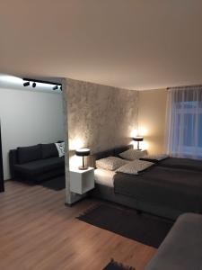 a living room with a bed and a couch at Viesu māja Stadula in Skrunda
