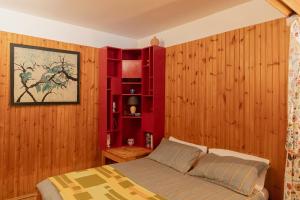 a bedroom with a bed and a red book shelf at Prali Ski House - 4beds - Parking - Garden in Prali