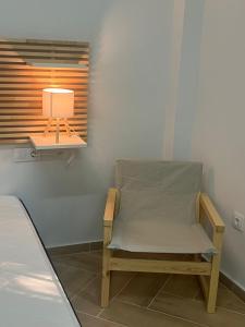 a chair sitting in a room with a lamp at Apartamento Villuercas in Cañamero
