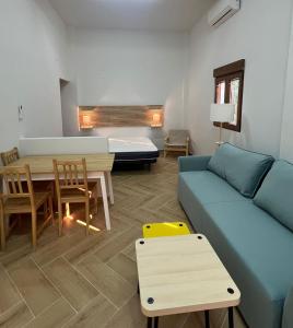 a living room with a blue couch and a table at Apartamento Villuercas in Cañamero