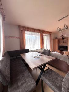 a living room with a table and a couch at Fewos Wuzella Faaker See in Latschach