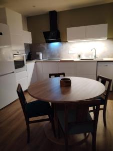 eine Küche mit einem Holztisch und Stühlen in der Unterkunft Le3cent85 in Saint-Germain-Laval