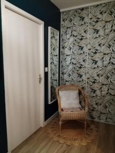 ein Korbsessel in einem Raum mit einer Wand in der Unterkunft Le3cent85 in Saint-Germain-Laval