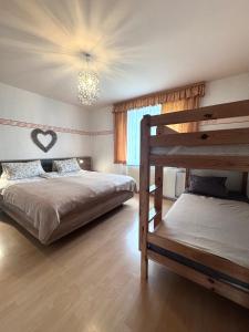 a bedroom with two bunk beds and a chandelier at Fewos Wuzella Faaker See in Latschach
