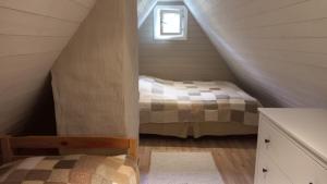 a attic bedroom with a bed and a window at Lohusalu Apartment in Lohusalu