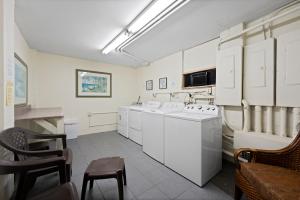 a kitchen with white appliances and a table and chairs at Outrigger Beach Club Resort by CoolVacay in Ormond Beach