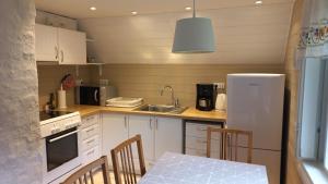 a kitchen with a white refrigerator and a table with chairs at Lohusalu Apartment in Lohusalu