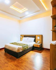 a bedroom with a bed and a wooden floor at Hotel Casa Santiago in Pasto