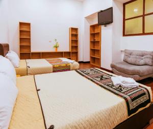 a living room with two beds and a chair at Hotel Casa Santiago in Pasto