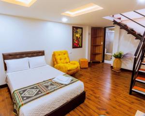 a bedroom with a bed and a yellow chair at Hotel Casa Santiago in Pasto +44 photos