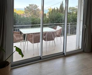 eine Glasschiebetür mit Tisch und Stühlen auf einem Balkon in der Unterkunft Farelleta in Llança
