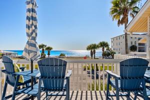 a patio with a table and chairs and the beach at Beach Escape, King Suite, Ocean Views, Pet Friendly in Destin